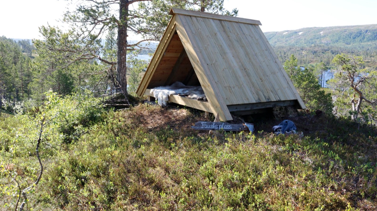 Gapahuken Fausks plass på en furukledd rabb over Langvatnet